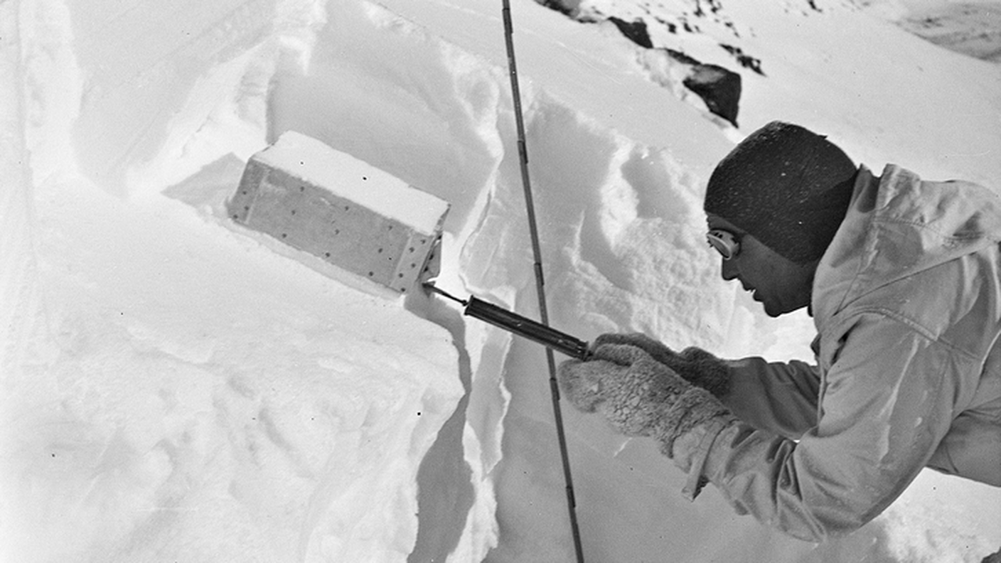 Il glaciologo Robert Haefeli esamina il manto nevoso con un dispositivo per il taglio degli strati. Davos (GR). Foto: Edwin Bucher, inverno 1937/1938 