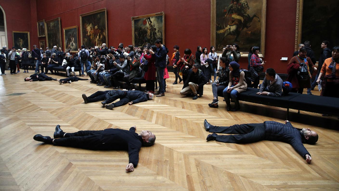 I manifestanti stesi a terra tra gli altri ospiti del museo