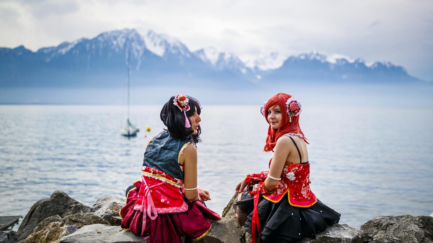 Due cosplayer sedute su una spiaggia del lago di Ginevra