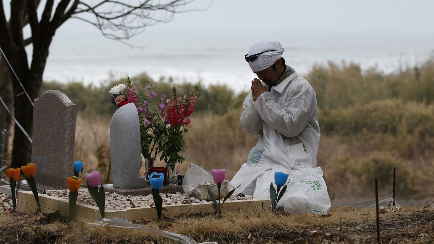 Norio Kimura prega davanti alla tomba dei famigliari deceduti quattro anni prima