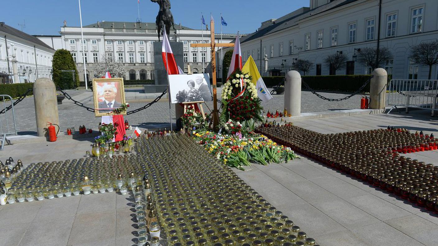 Corone di fiori, lumini e bandiere davanti al palazzo presidenziale a Varsavia