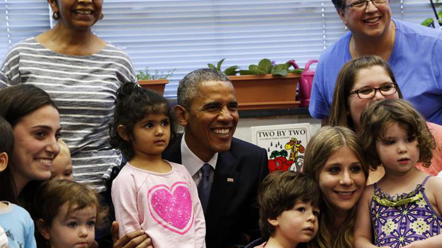 Barack Obama circondato dai bambini in una foto Ansa d'archivio