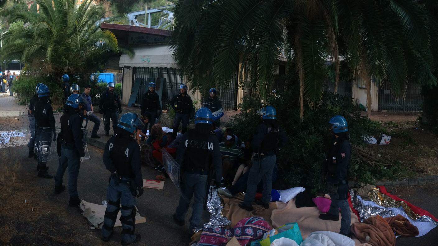 La polizia italiana intorno ai migranti che resistono in maniera pacifica e passiva