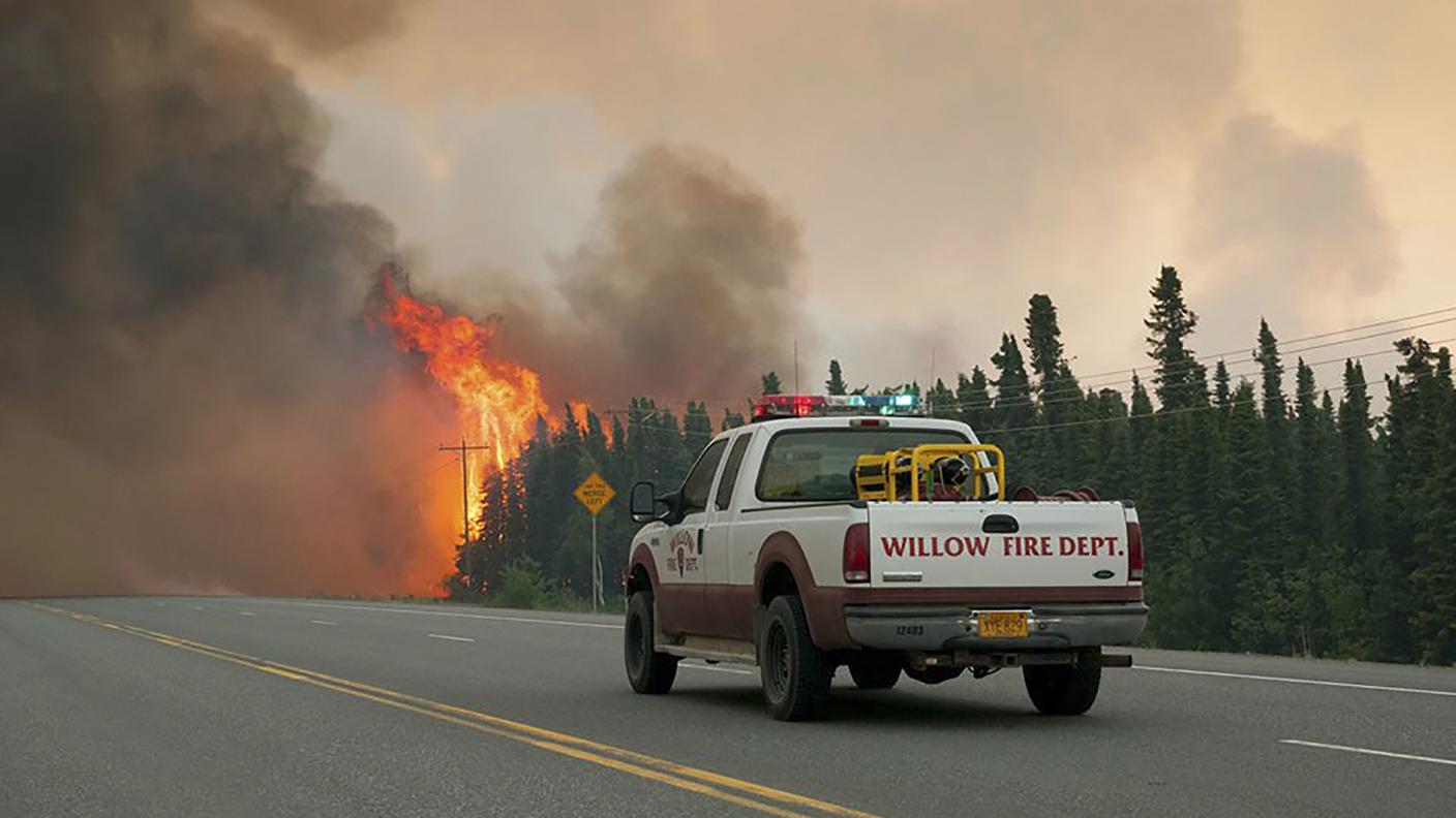 Un pick-up dei pompieri locali davanti alle fiamme che devastano l'Alaska
