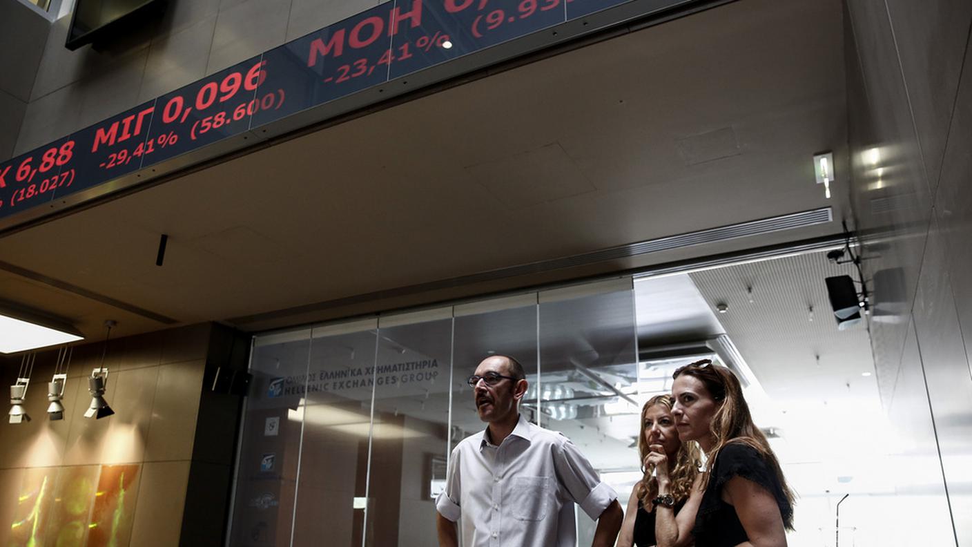 Impiegati e trader osservano il crollo dei listini
