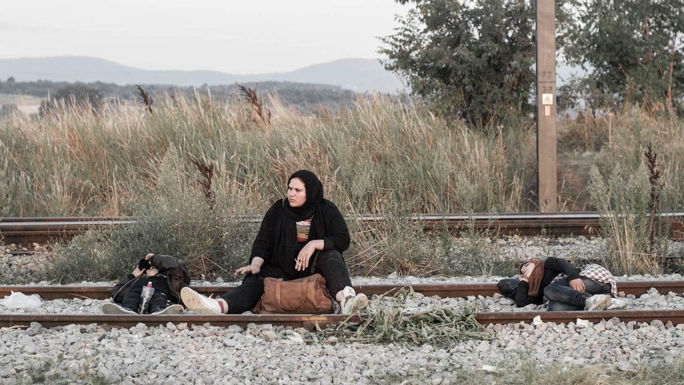 Tre giovani siriane si riposano. L'attesa, prima che i migranti vengano lasciati proseguire oltre il confine, può durare ore.