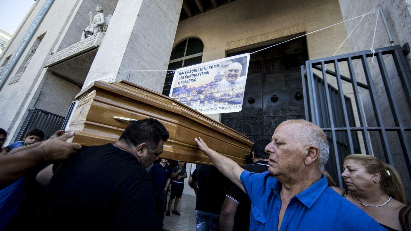 Persone in lutto sfiorano il feretro di Vittorio Casamonica a Roma