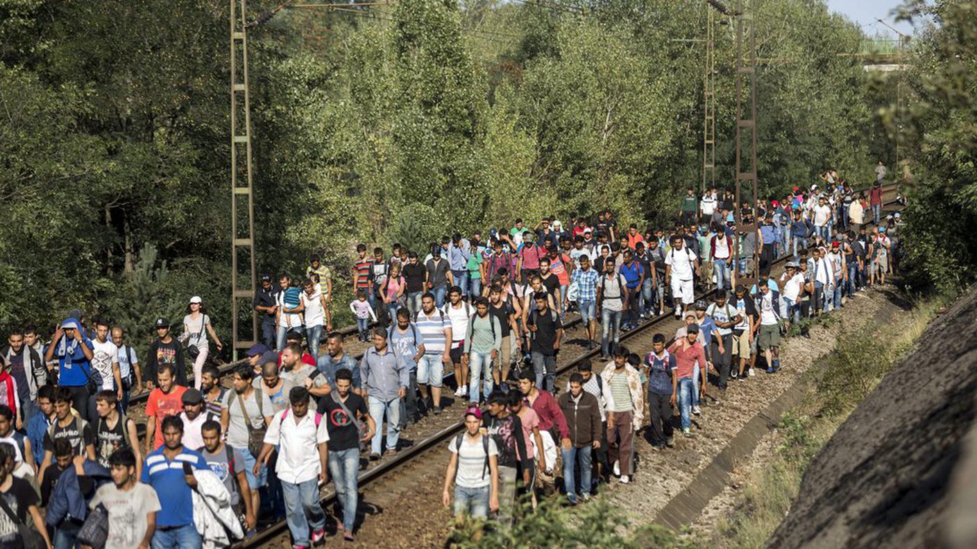 Centinaia di migranti che erano rimasti bloccati su un treno si sono allontanati venerdì lungo i binari dalla stazione di Roszke