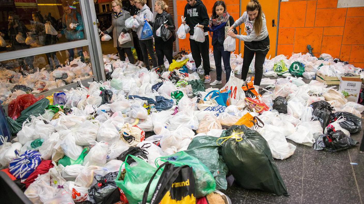Sacchetti con generi di prima necessità per i migranti in arrivo; in Germania si assiste a una grande mobilitazione di volontari