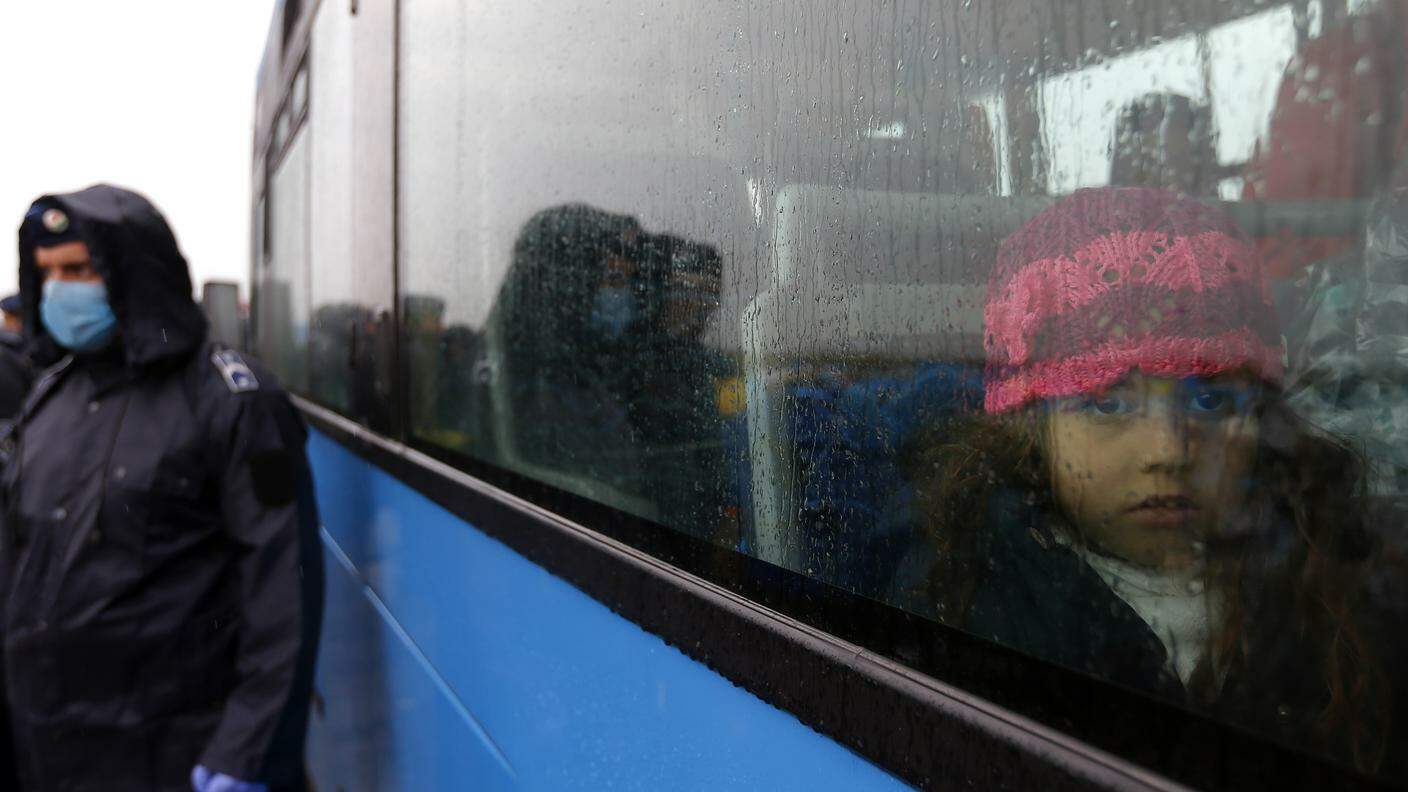 Una bambina guarda dal finestrino di un autobus che parte da Szeged