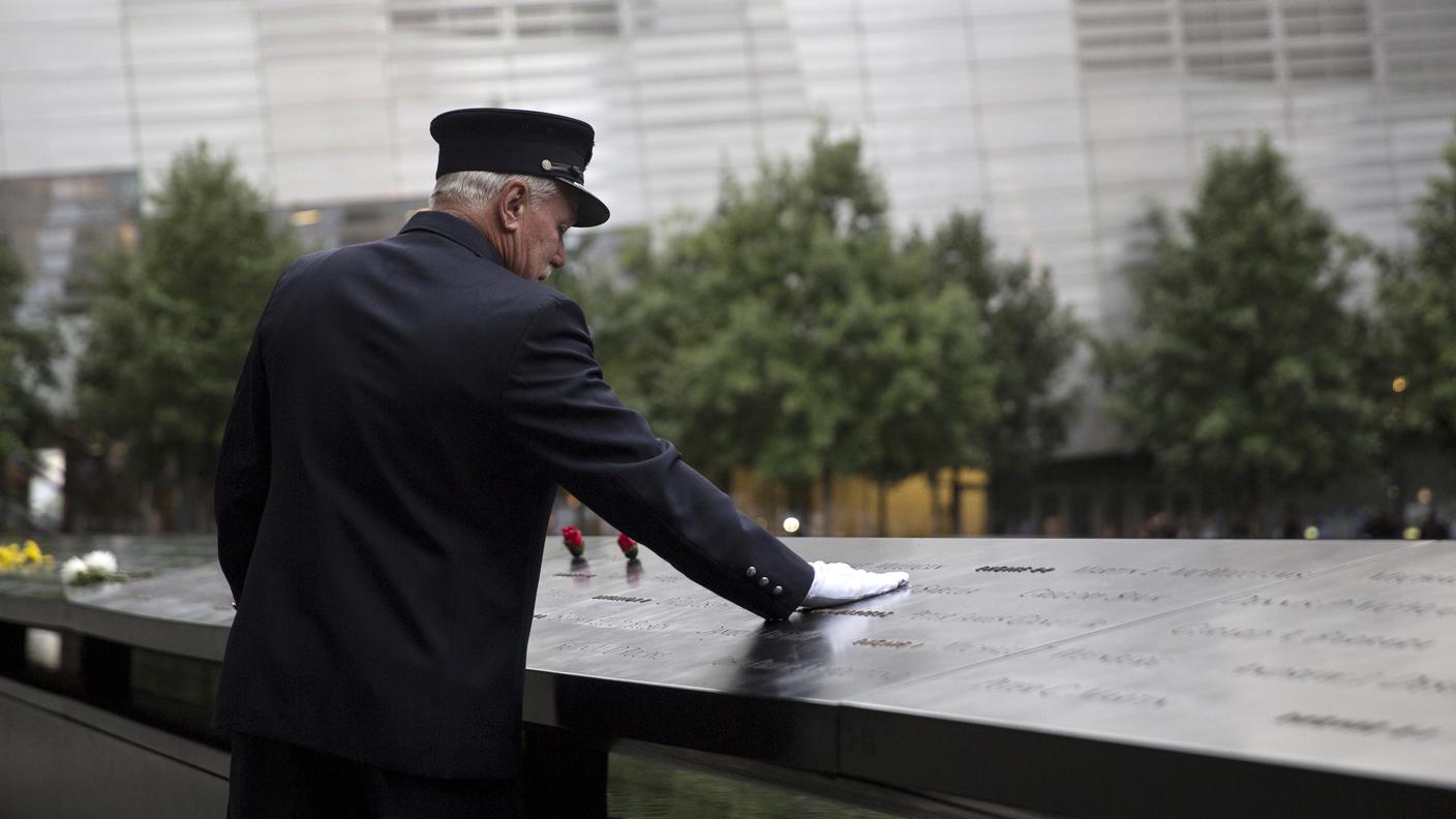 Un membro dei vigili del fuoco al memoriale per le vittime