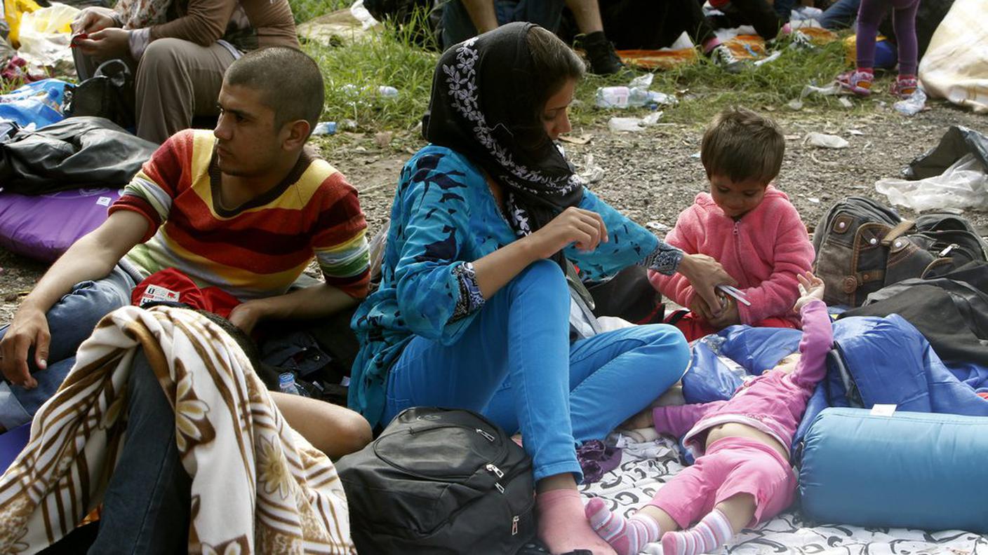 Una famiglia di siriani davanti alla barriera ungherese