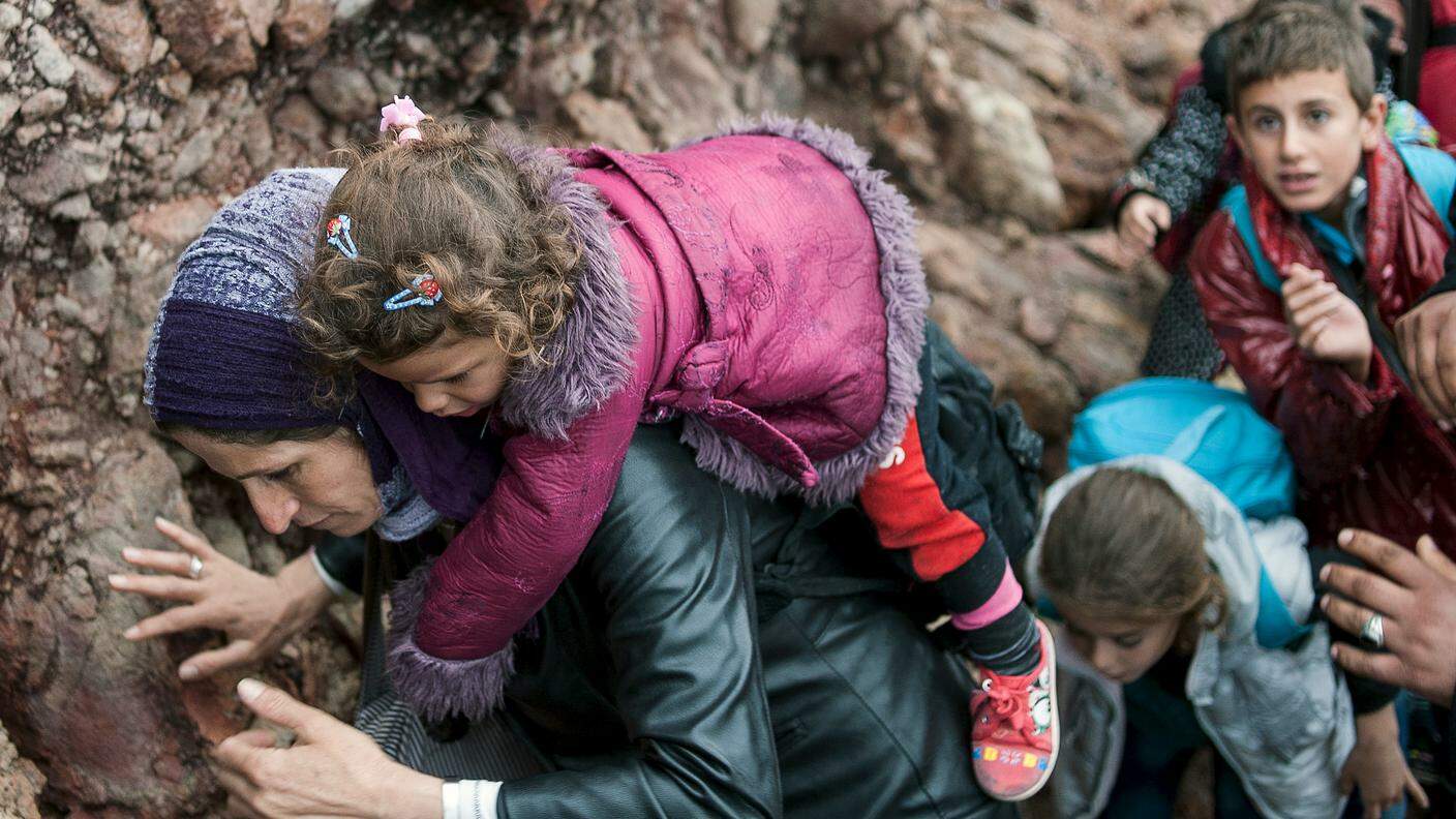 Una migrante con la sua bambina, appena dopo lo sbarco a Lesbo