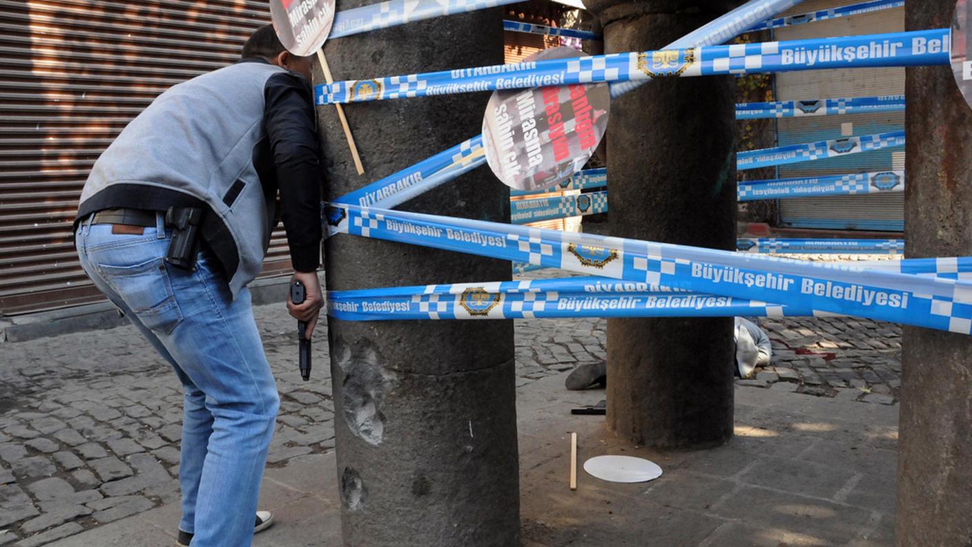 Un agente vicino al corpo di Tahir Elci, caduto sotto i colpi sparati da un'auto