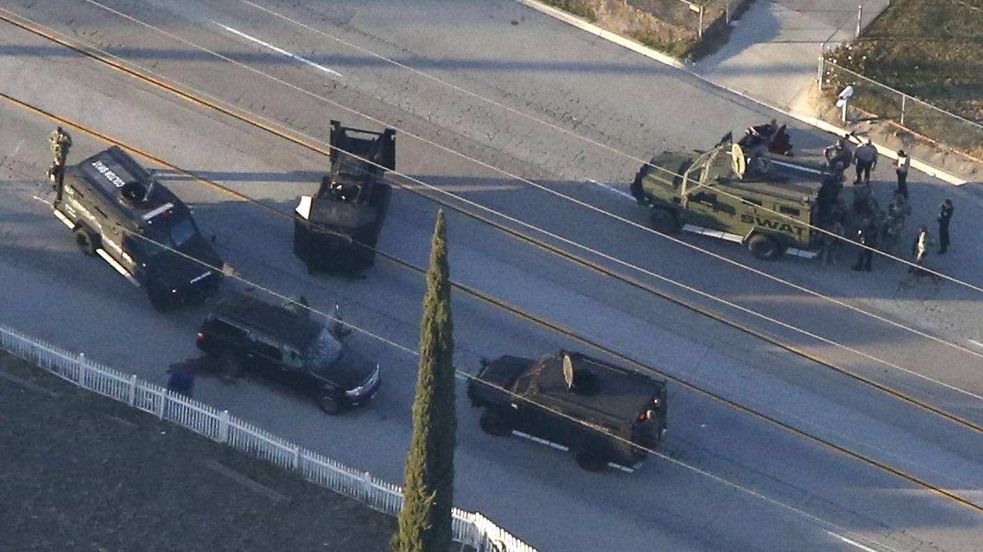 Le forze dell'ordine circondano il SUV a bordo del quale fuggivano i sospettati