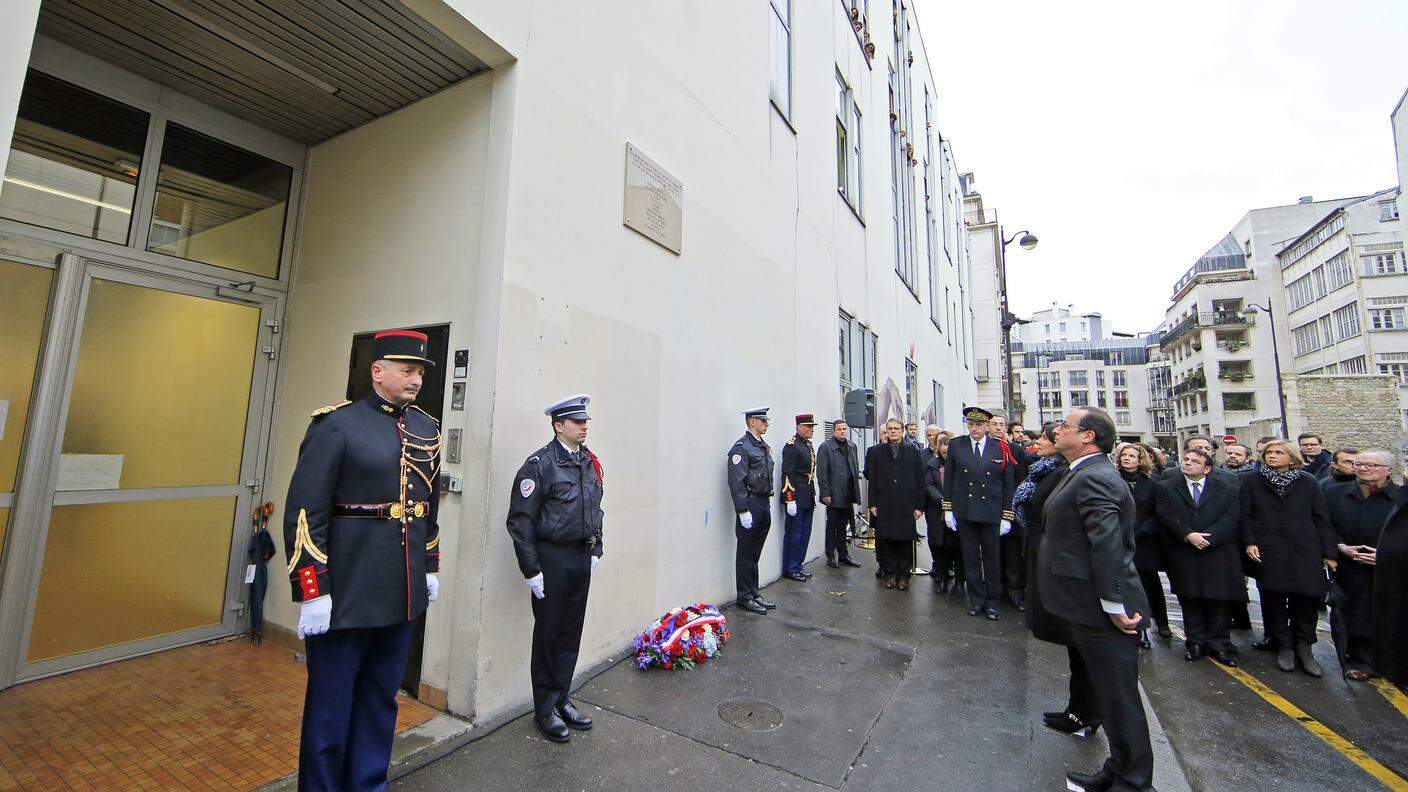 Hollande di fronte alla targa commemorativa in rue Nicolas Appert, dove sorgeva la sede del giornale