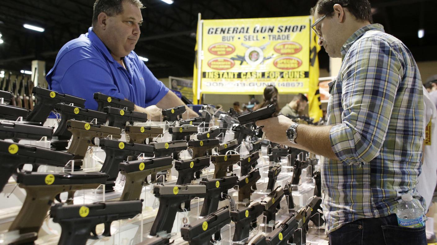 Un cliente esamina una pistola durante il Florida Gun Show, una fiera del settore