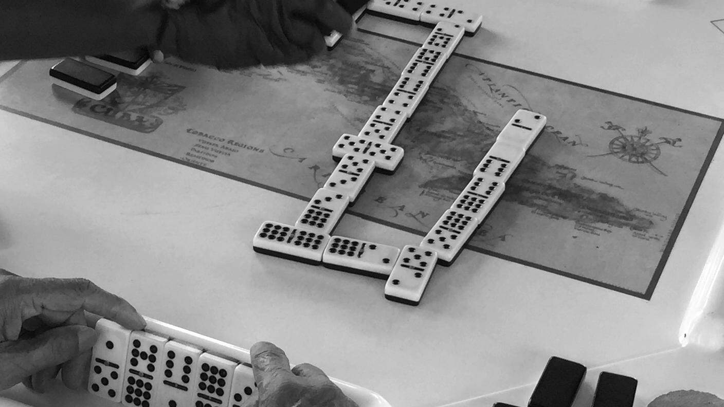 NOSTALGIA - La mappa di Cuba stampata sui tavolini del parco dove si gioca a domino, nel quartiere cubano di Miami. Tessere e numeri sembrano tracciare una strada verso L'Havana