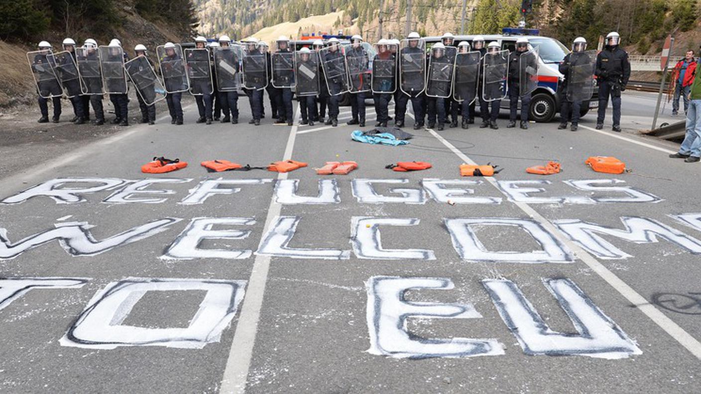 "Rifugiati, benvenuti nell'UE". Una scritta di protesta, sul manto stradale, davanti al cordone formato dai poliziotti austriaci