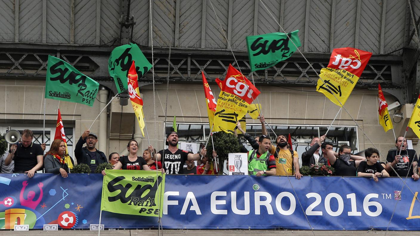 Ferrovieri in sciopero a la Gare de l'Est di Parigi davanti a uno striscione di Euro 2016