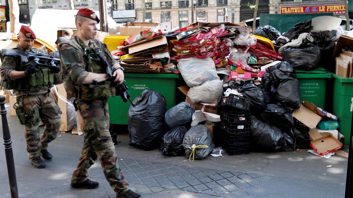 Soldati francesi di pattuglia in mezzo a cumuli di spazzatura a Parigi