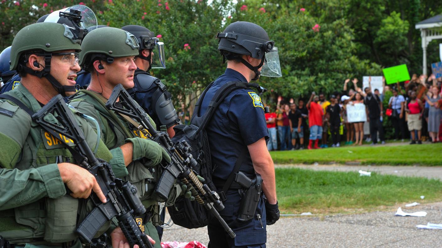 Poliziotti con armi da guerra fronteggiano i manifestanti a Baton Rouge