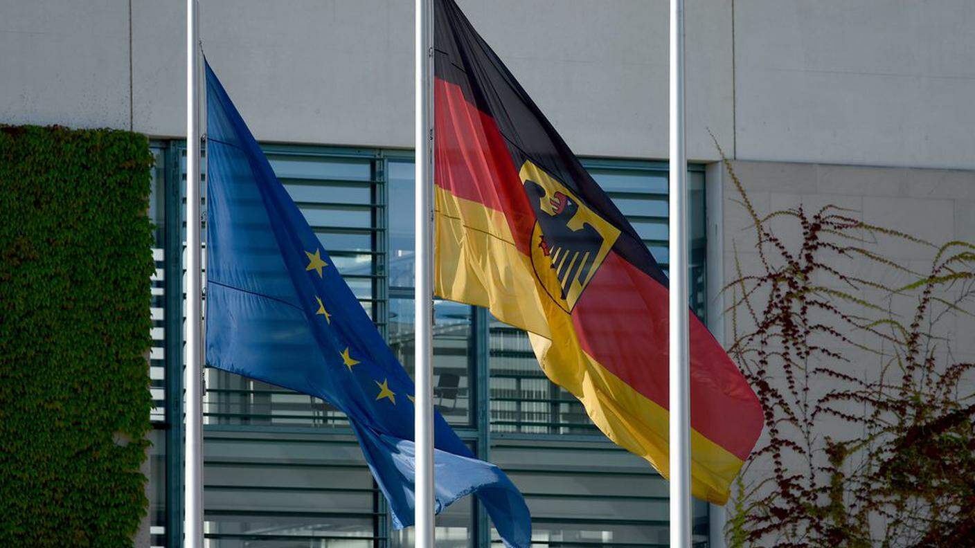 La bandiera tedesca e quella europea a mezz'asta di fronte alla cancelleria federale a Berlino