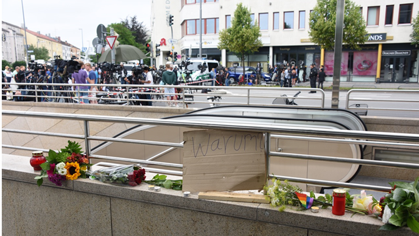 Tra i fiori un cartello chiede il perché della strage