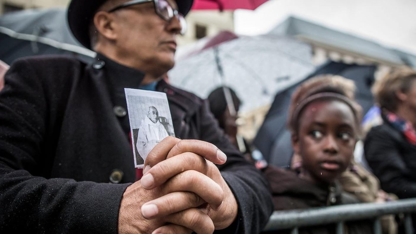 Un uomo tiene in mano la foto di padre Jacques Hamel