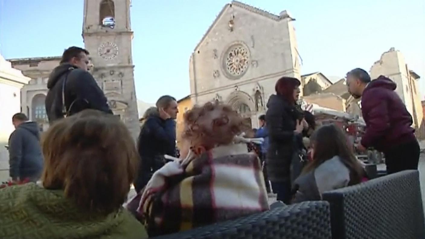 Sfollati di fronte alla cattedrale crollata di Norcia