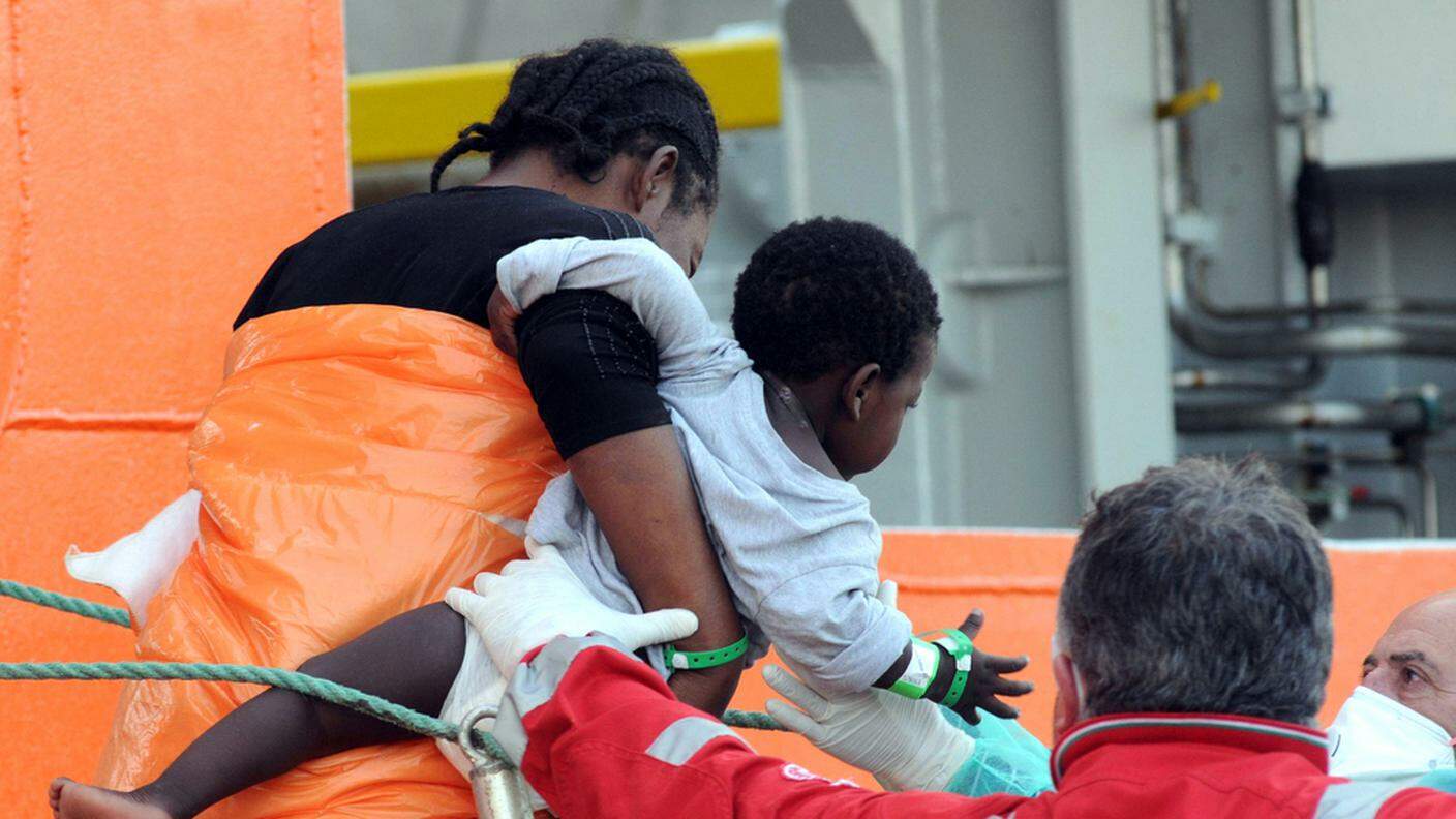 Migranti ricevono i primi soccorsi al porto di Palermo