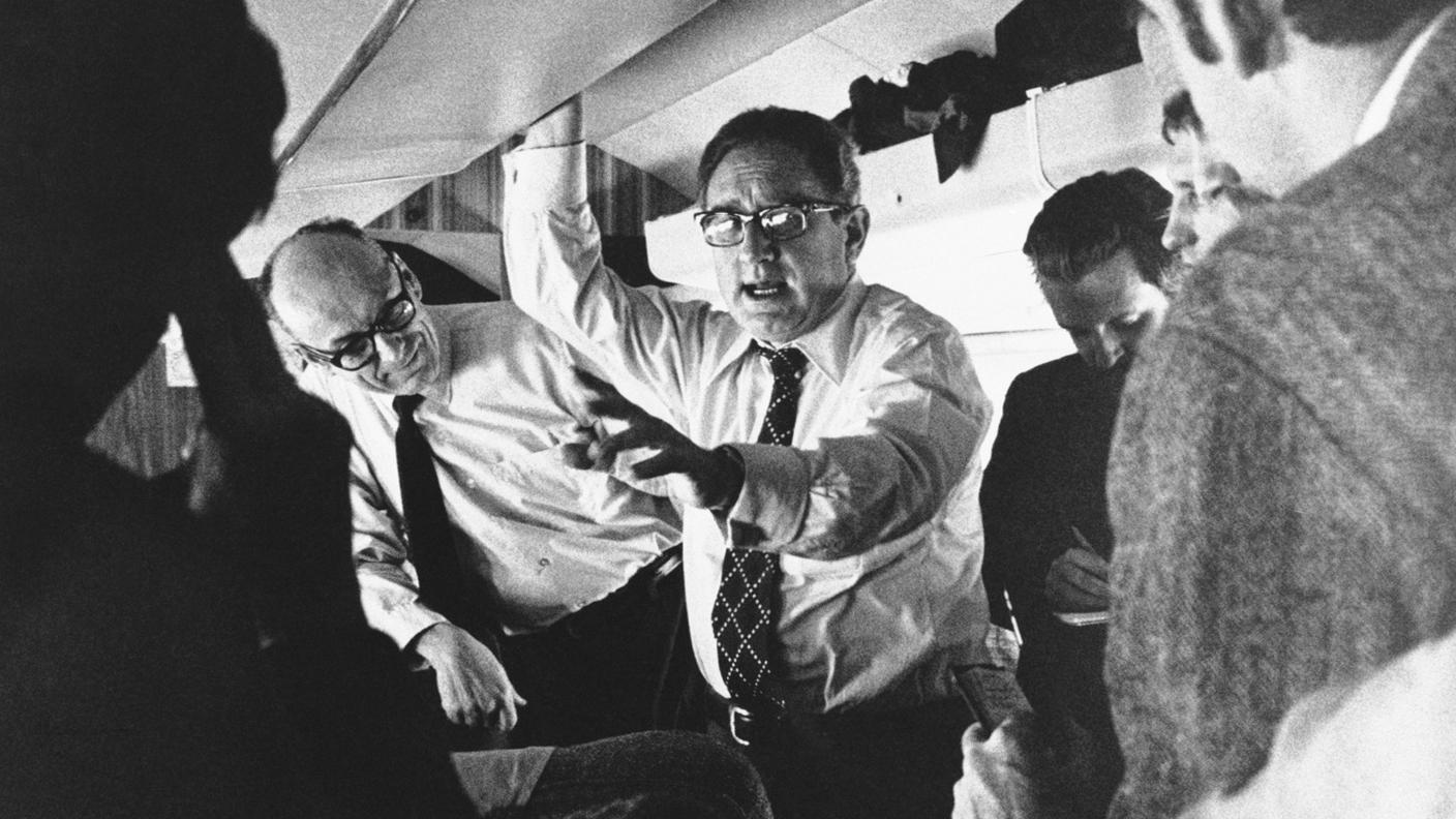 Kissinger, il suo staff e i giornalisti al seguito, in volo, nel 1973, in vista di una riunione dei ministri degli esteri della NATO: instancabile "globetrotter" della diplomazia, Kissinger si spostò con assiduità da un Paese all'altro, segnatamente in situazioni di crisi