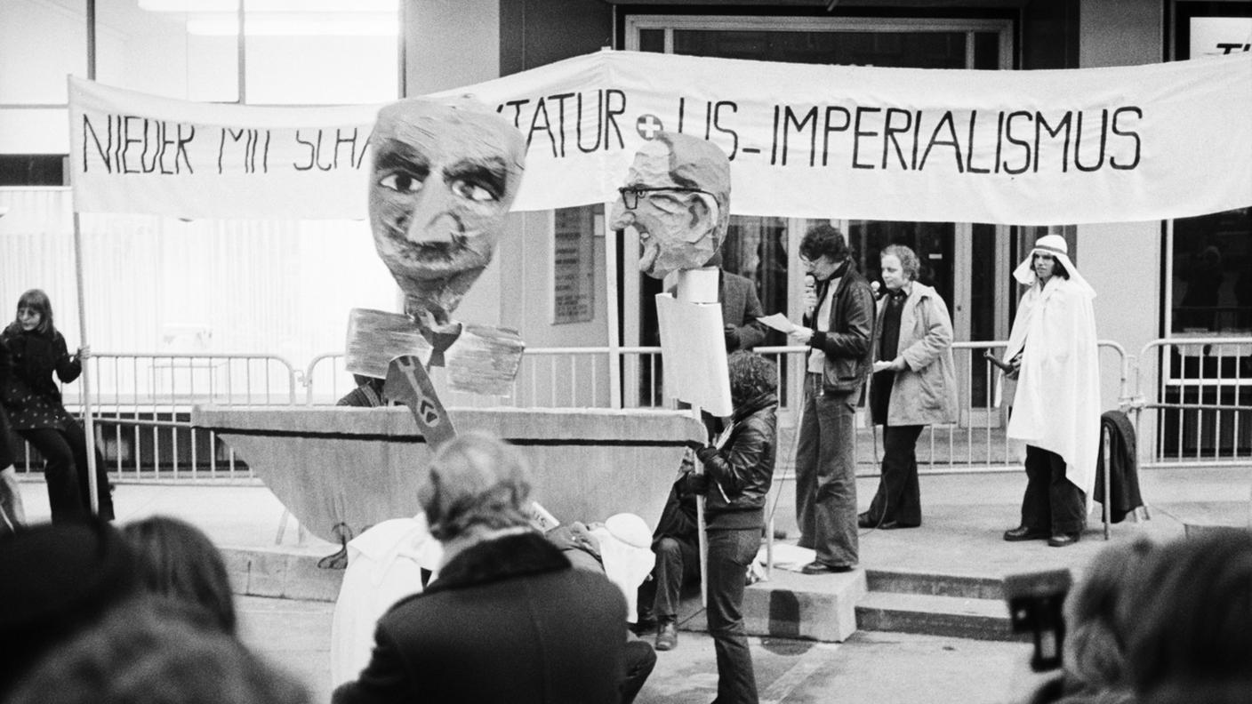 Manifestanti, e fantocci di cartapesta raffiguranti Kissinger e lo scià Reza Pahlavi, in una dimostrazione di protesta contro il loro incontro a Zurigo, nel febbraio del 1975