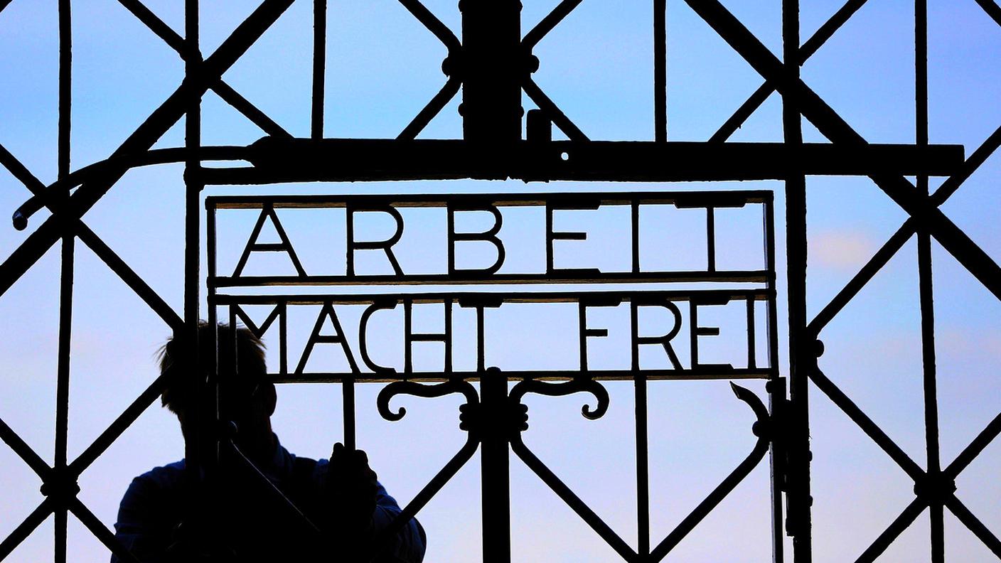 29 aprile 2015: un fabbro sistema la replica della scritta di Dachau