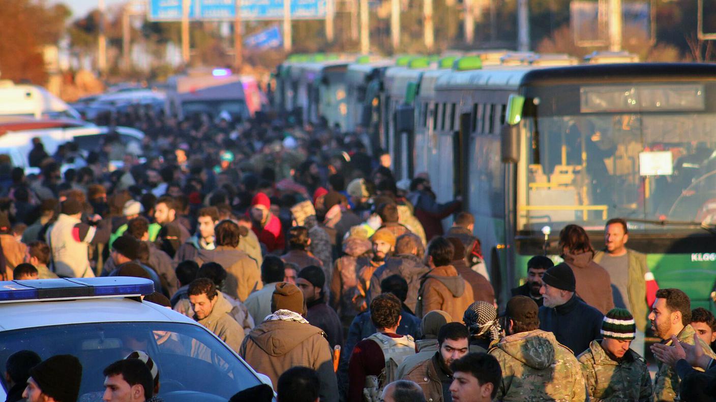 Migliaia di persone in attesa di salire sui pullman per lasciare Aleppo