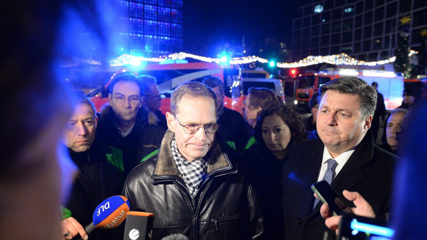 Il sindaco di Berlino, Michael Müller, attorniato da fotografi e giornalisti