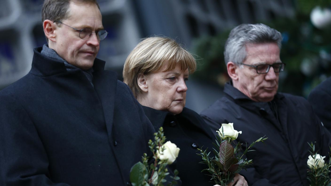 Il sindaco Mueller, la cancelliera Merkel e il ministro degli interni de Maiziere 