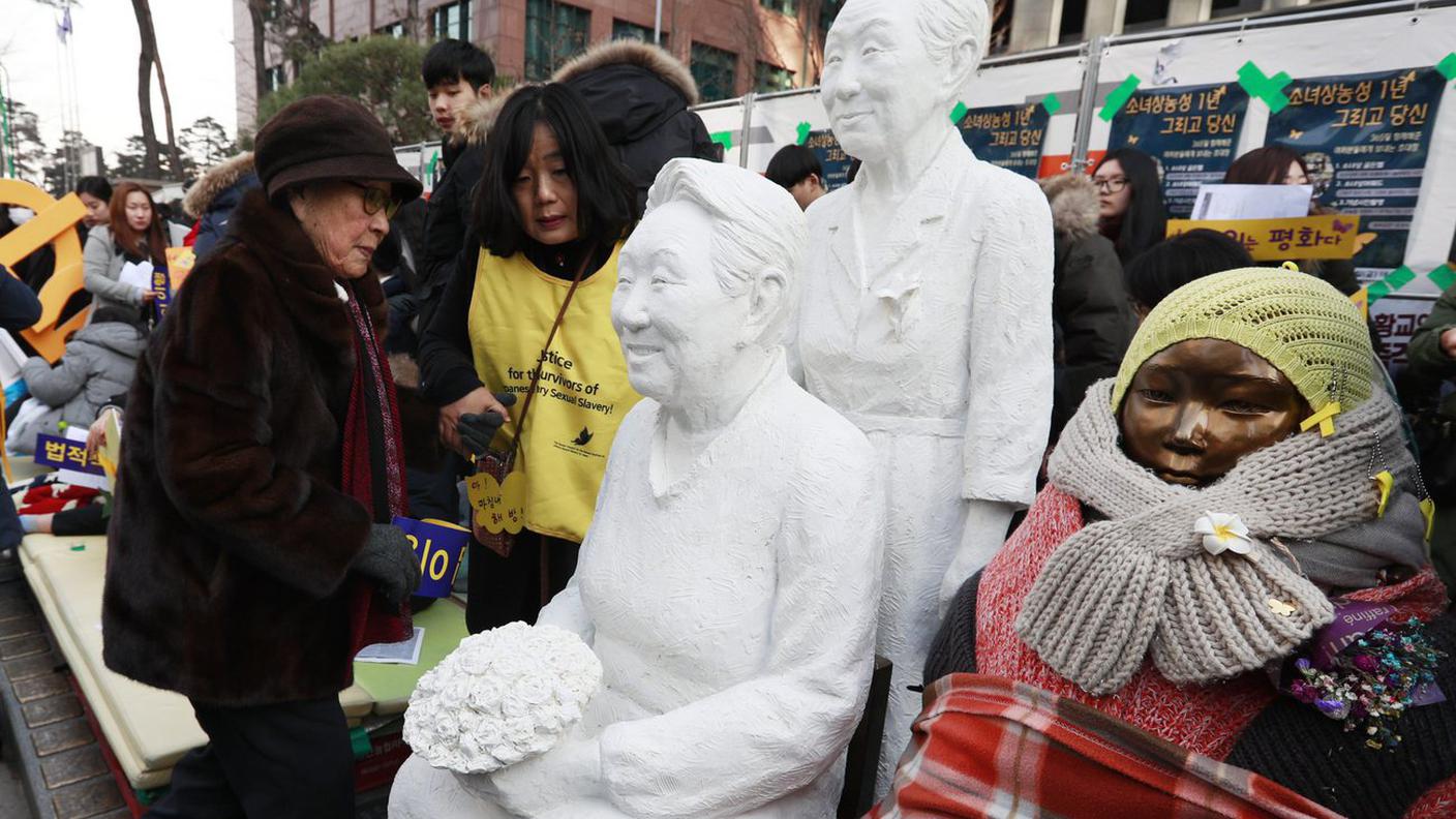 Kim Bok-dong (a sinistra), un'ex schiava sessuale, accanto a una delle statue che la rappresenta