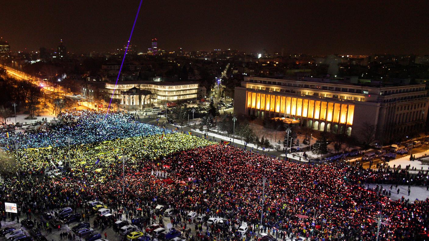 L'enorme bandiera romena formata dai manifestanti a Bucarest