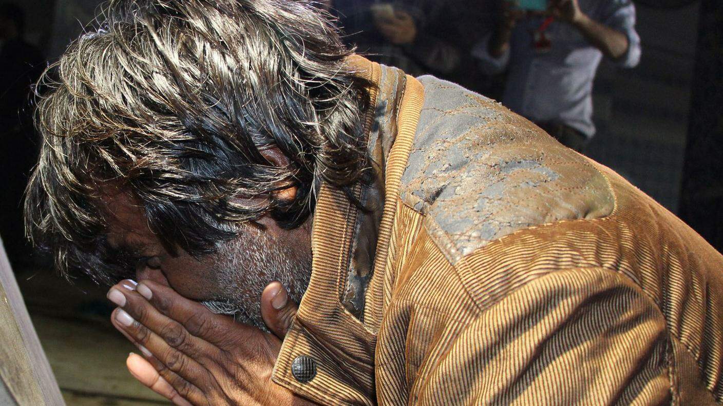 Un uomo sopraffatto dalla disperazione, dopo l'attentato kamikaze a Sehwan Sharif