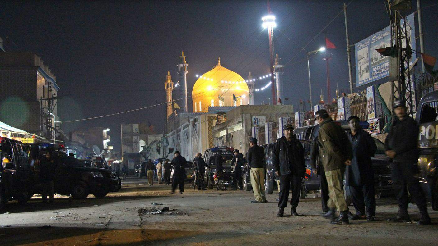 Sullo sfondo, il santuario sufi preso di mira dall'attentatore suicida