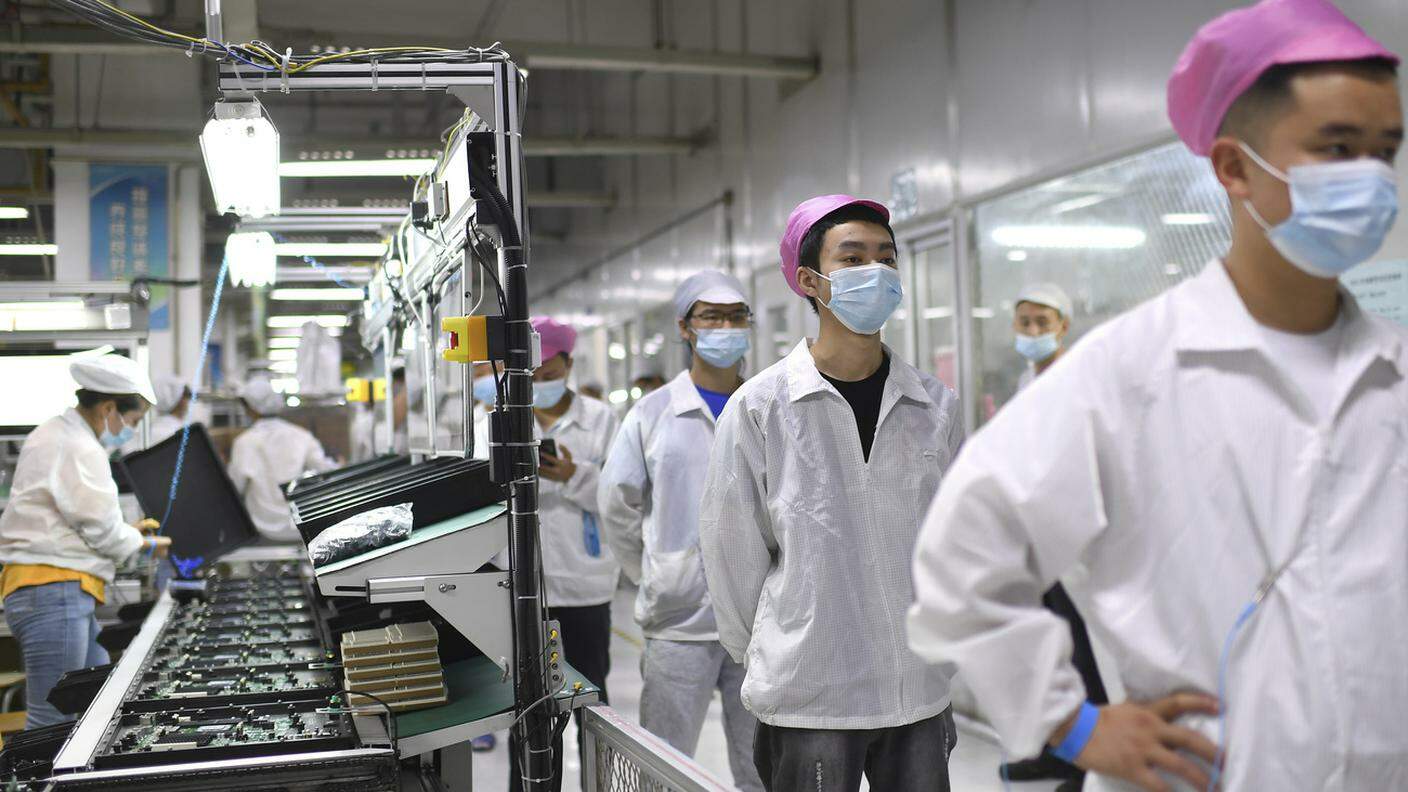 Operai in fila per sottoporsi al test COVID-19 presso la fabbrica Foxconn di Wuhan