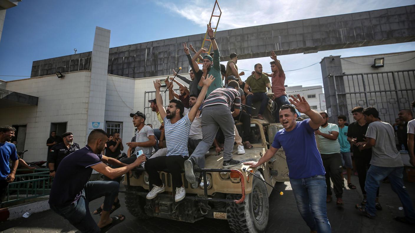 Palestinesi cavalcano una jeep militare israeliana nelle strade di Gaza durante l'assalto agli insediamenti nemici