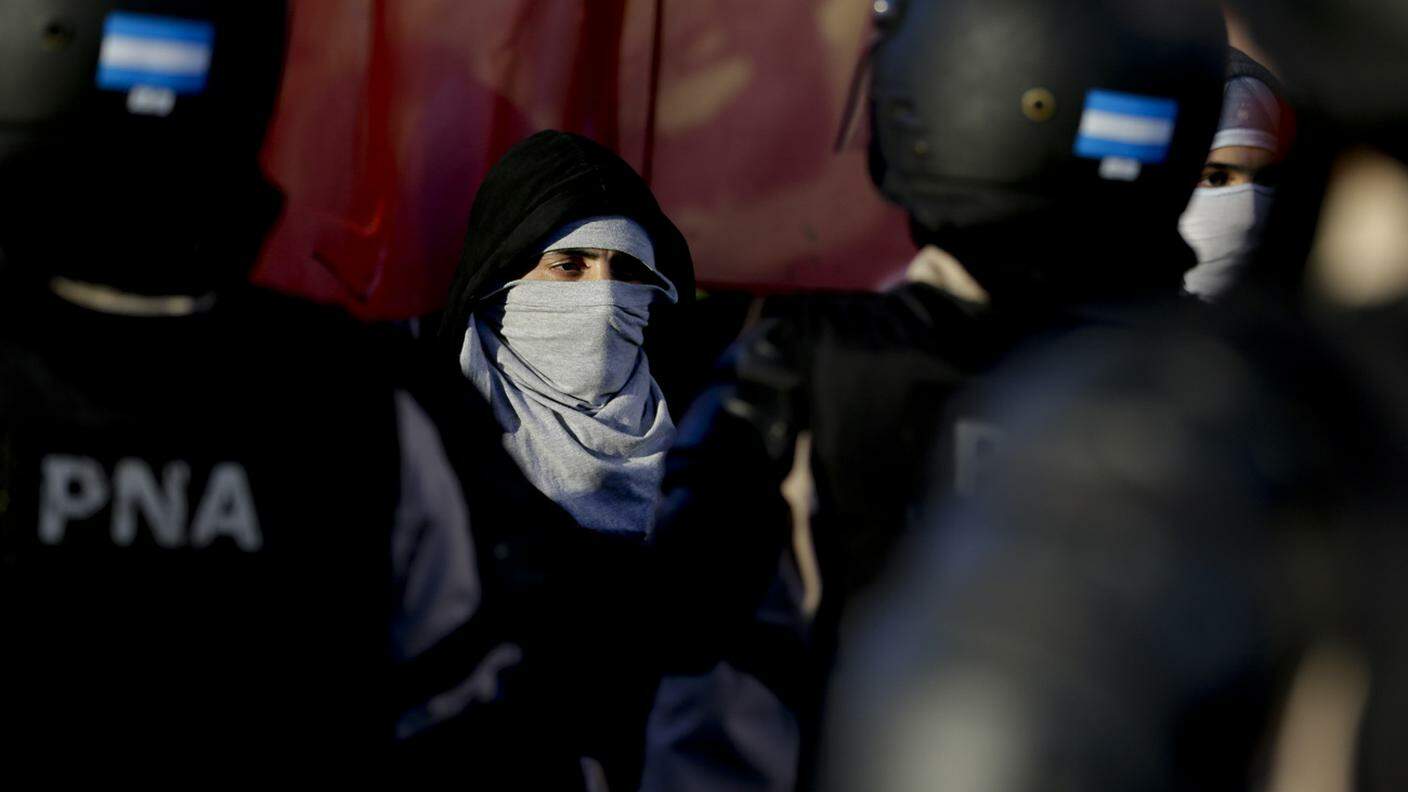 Un manifestante davanti ai poliziotti a Buenos Aires