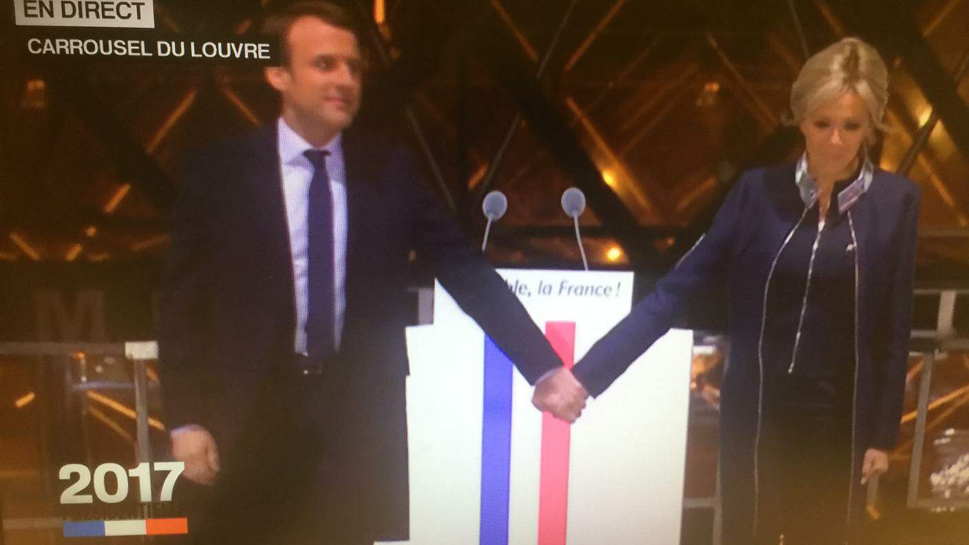 E la moglie Brigitte, neo première dame, raggiunge Emmanuel Macron sul palco. Poi parte la Marsigliese