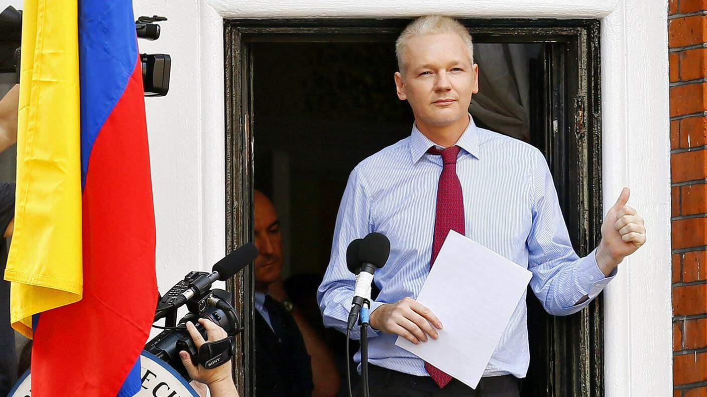 Assange al balcone dell'ambasciata ecuadoregna, dove è rifugiato da più di cinque anni 