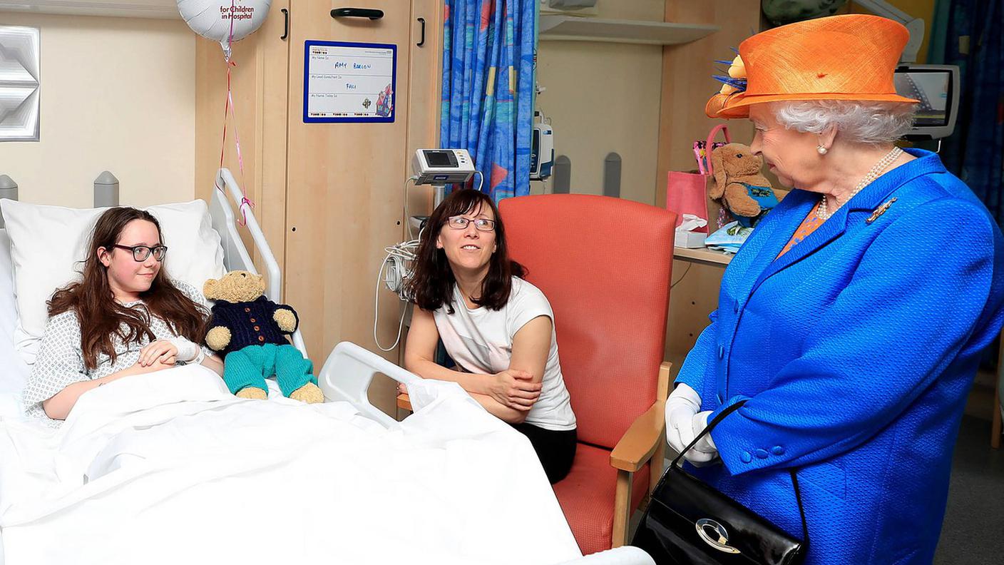 La regina Elisabetta II con una dei feriti ancora ricoverati in ospedale
