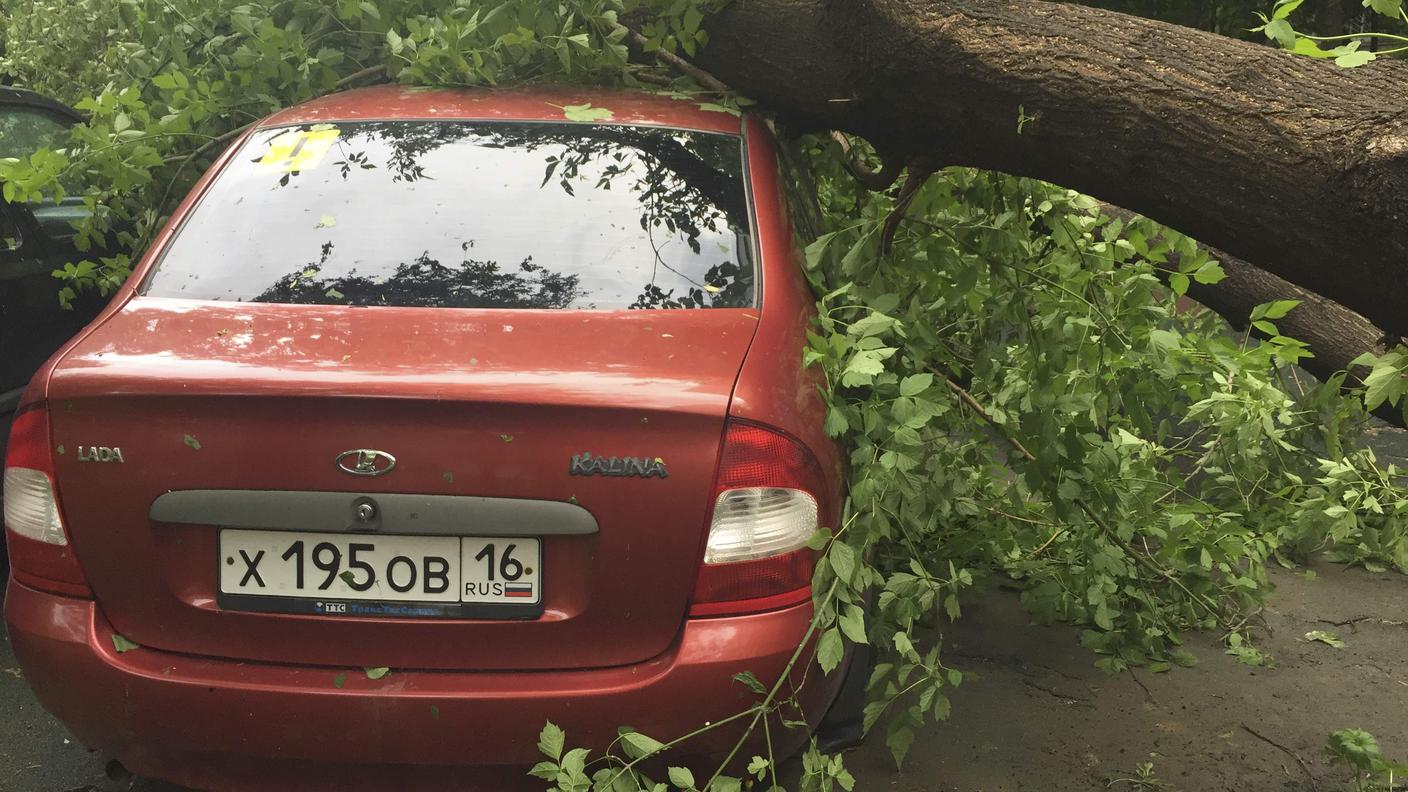 Una vettura schiacciata da un albero sradicato dal vento lunedì a Mosca
