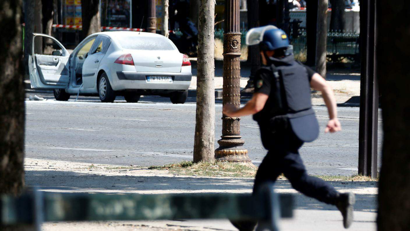 Un gendarme corre verso l'auto dell'attentatore, ricoperta dalla schiuma di estintori