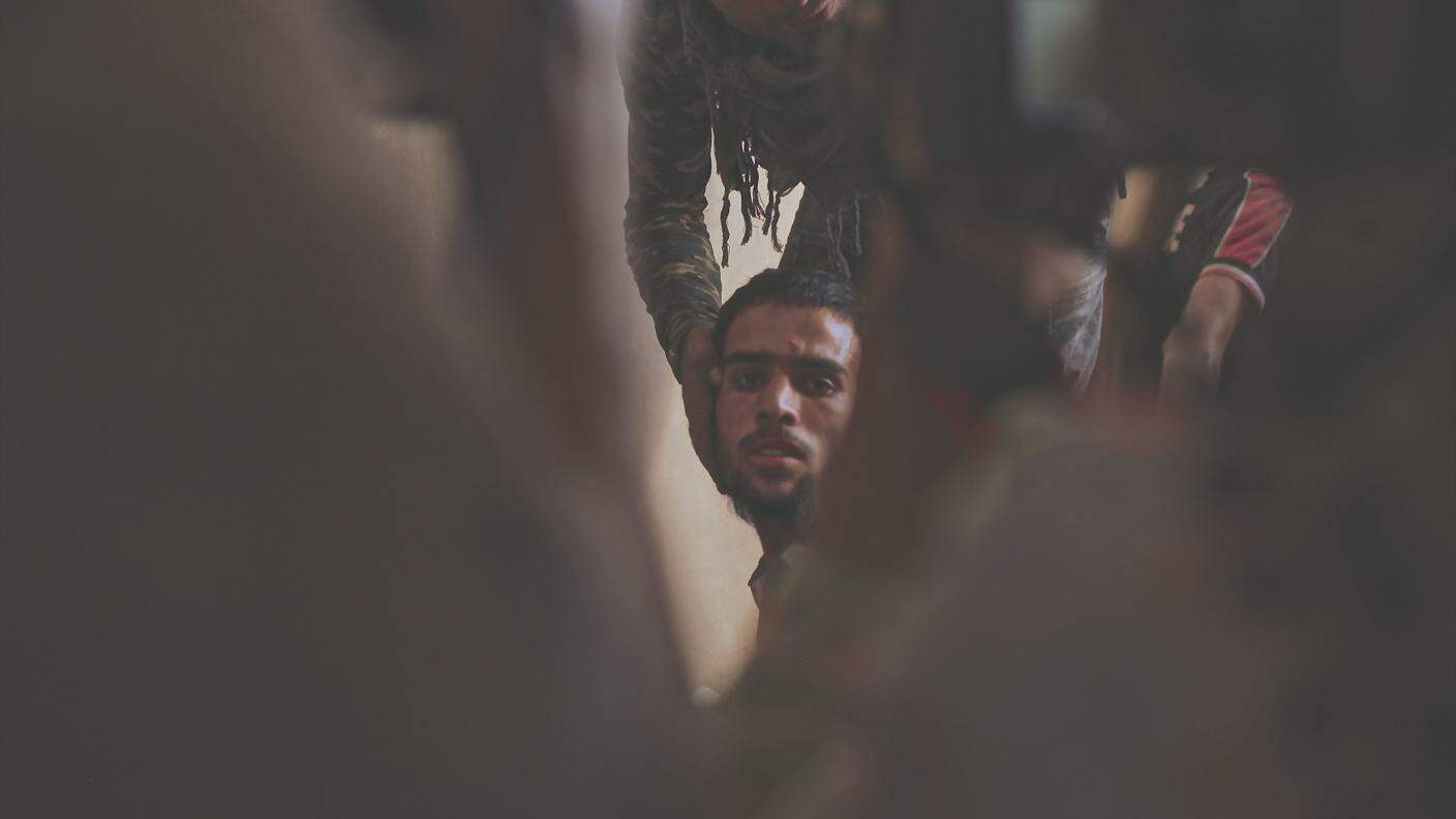 Mosul, Iraq – Uno dei tenenti della brigata costringe un prigioniero di Daesh a mostrare il volto ai giornalisti